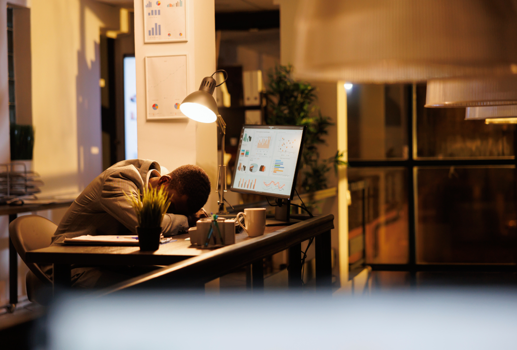 Persona acostada sobre su mesa de trabajo porque sufre burnout laboral.